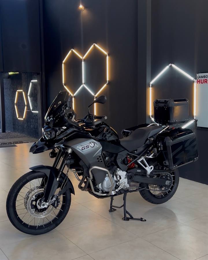 BMW F 850 GS preta com baús sob as luzes hexagonais do showroom